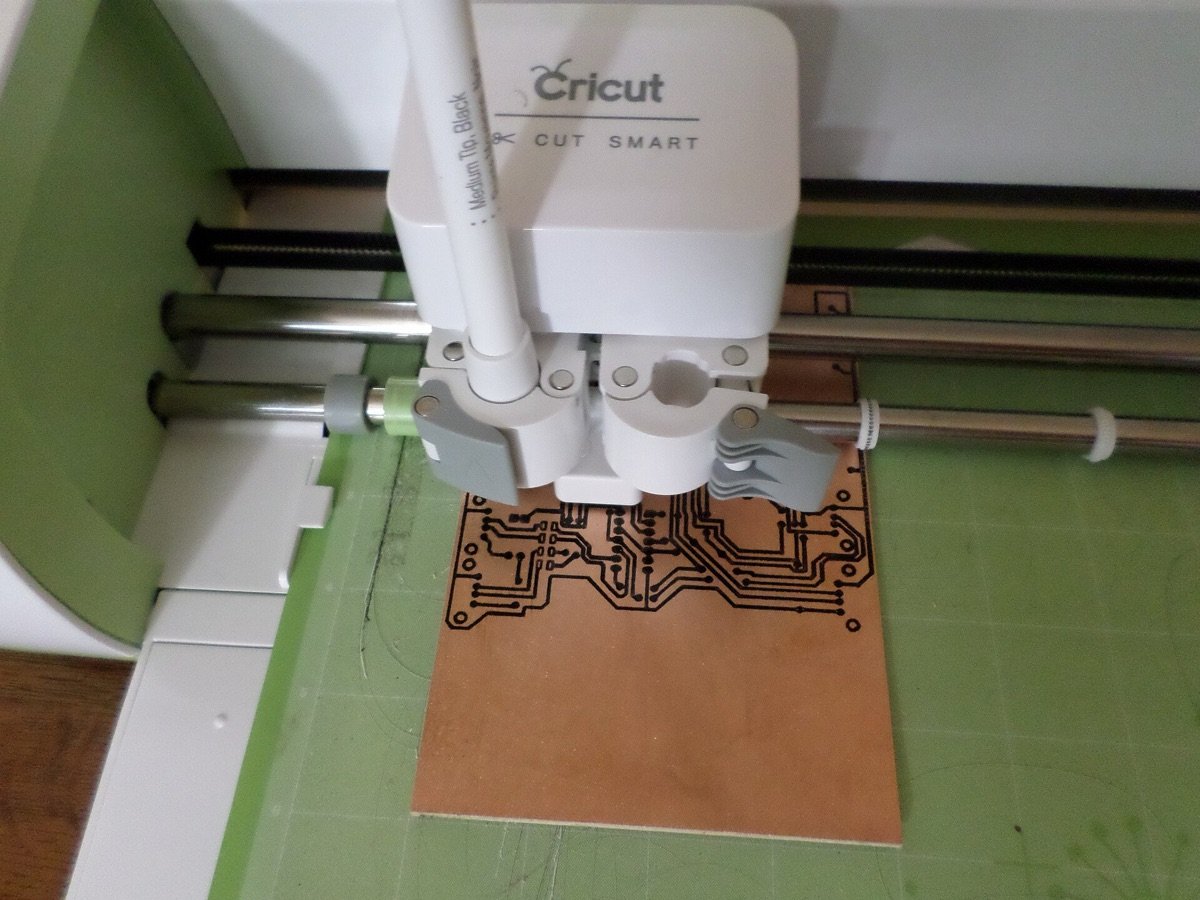 Plotter de corte Cricut cortando material sobre un tapete