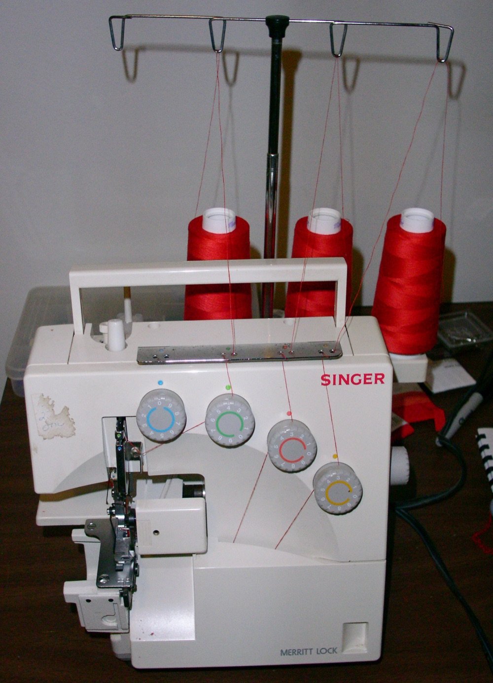 Remalladora Singer con tres conos de hilo rojo enhebrada